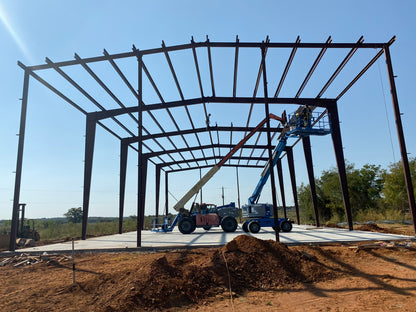 Construction site with a large metal framework under construction against a blue sky.
