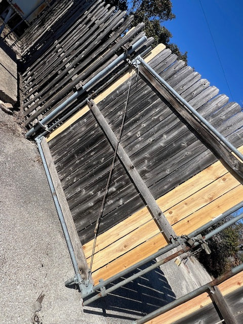 Repair of commercial outswing gate with wheel, welding, and picket replacement.