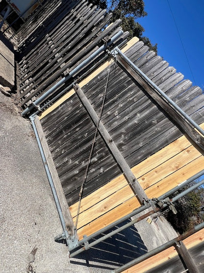 Repair of commercial outswing gate with wheel, welding, and picket replacement.