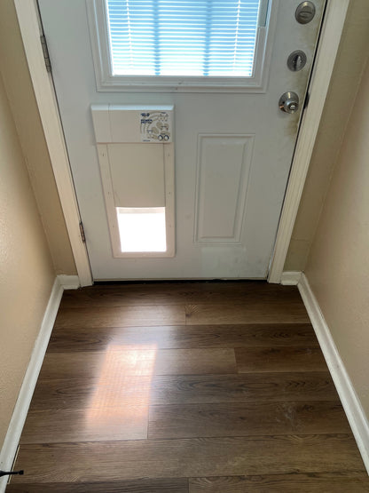 Rear entry home door with medium pet door install to match paneling.