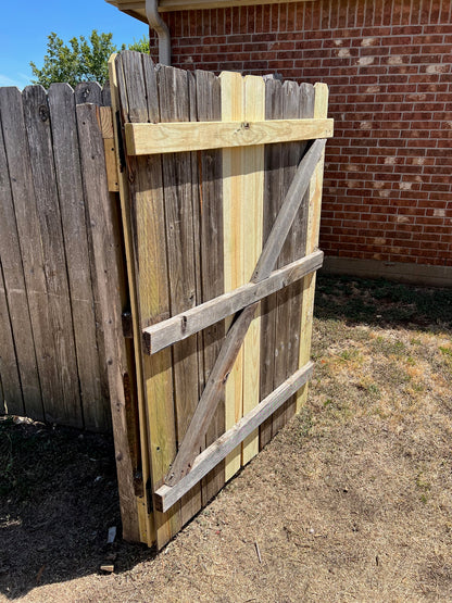 Privacy fence gate repaired and standing open to show the replaced bracing and functional hinge operation