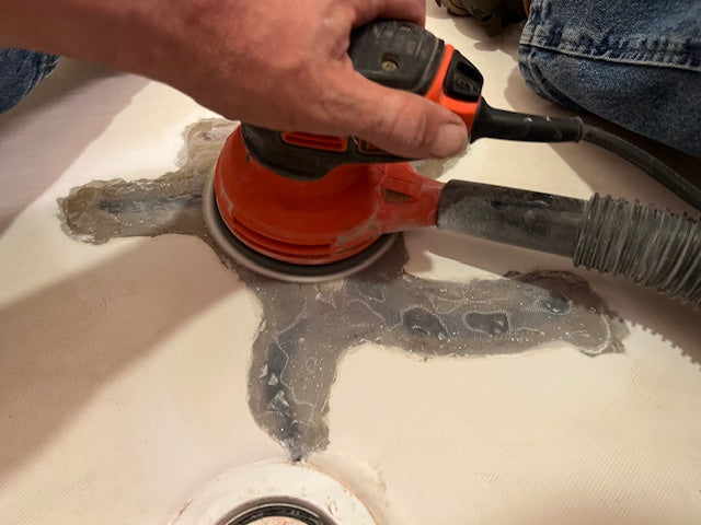 Person using a sanding machine while repairing a fiber glass surface