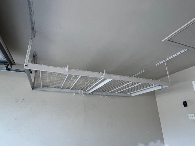 Garage ceiling with storage tote hanging shelf over vehicle