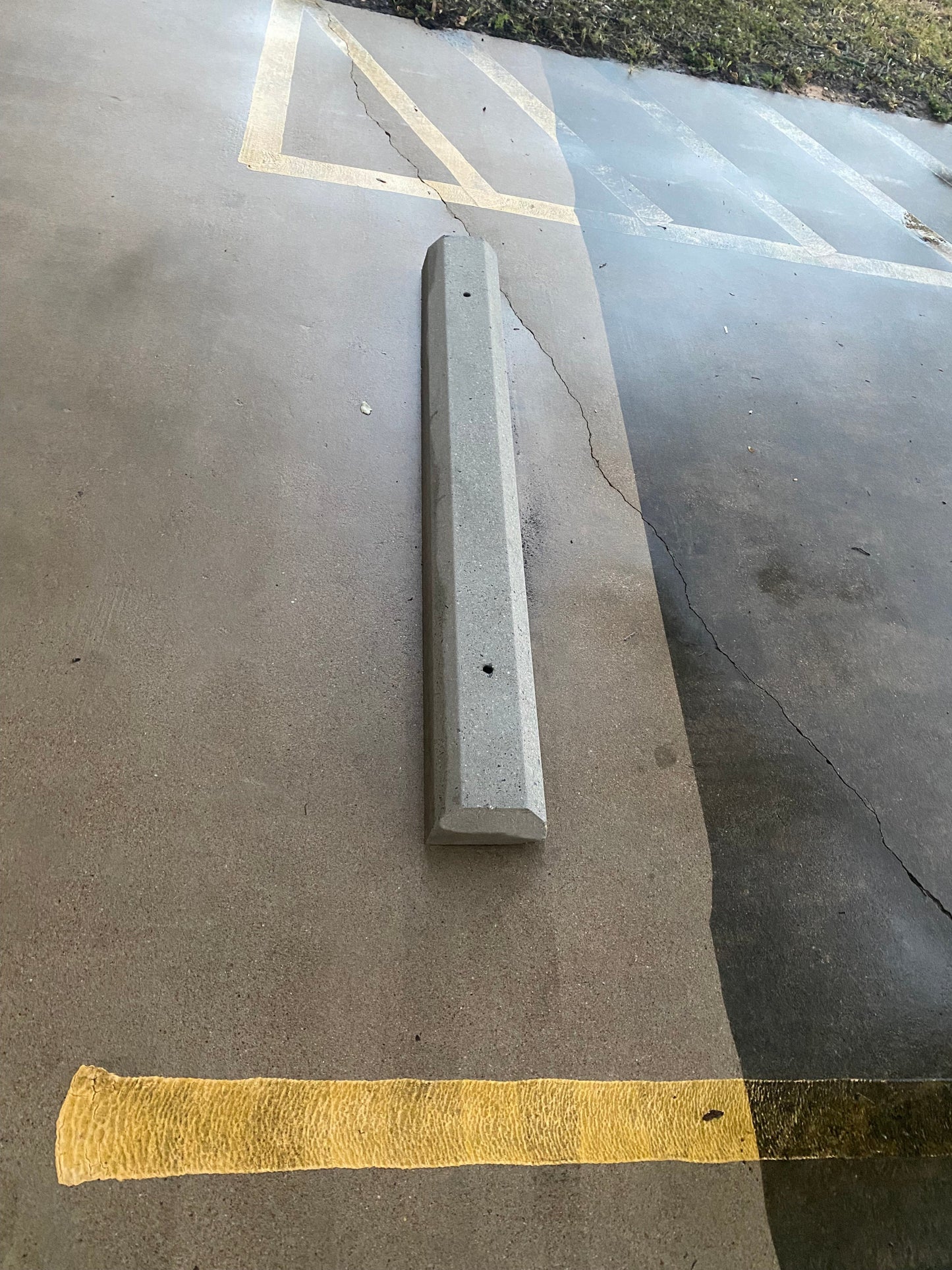 Example pressure washed concrete parking block on a concrete surface with yellow parking lines