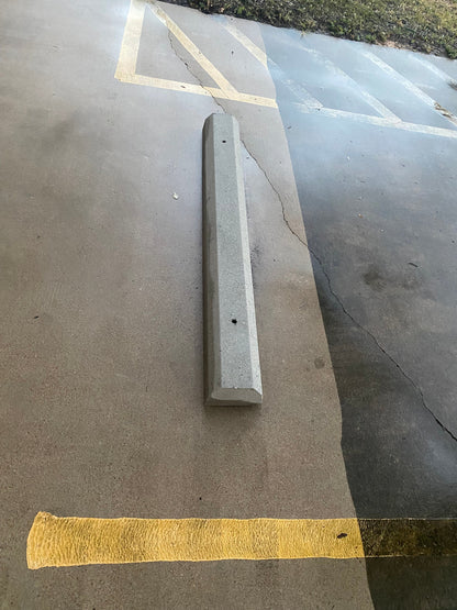 Example pressure washed concrete parking block on a concrete surface with yellow parking lines