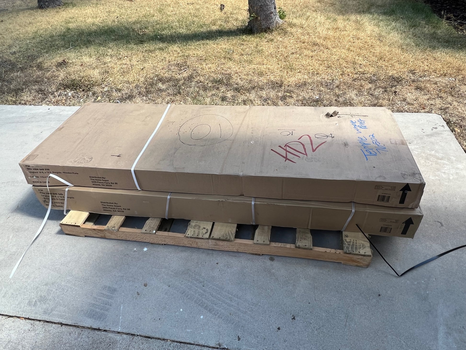 Stack of unopened cardboard boxes on a wooden pallet outdoors before pic