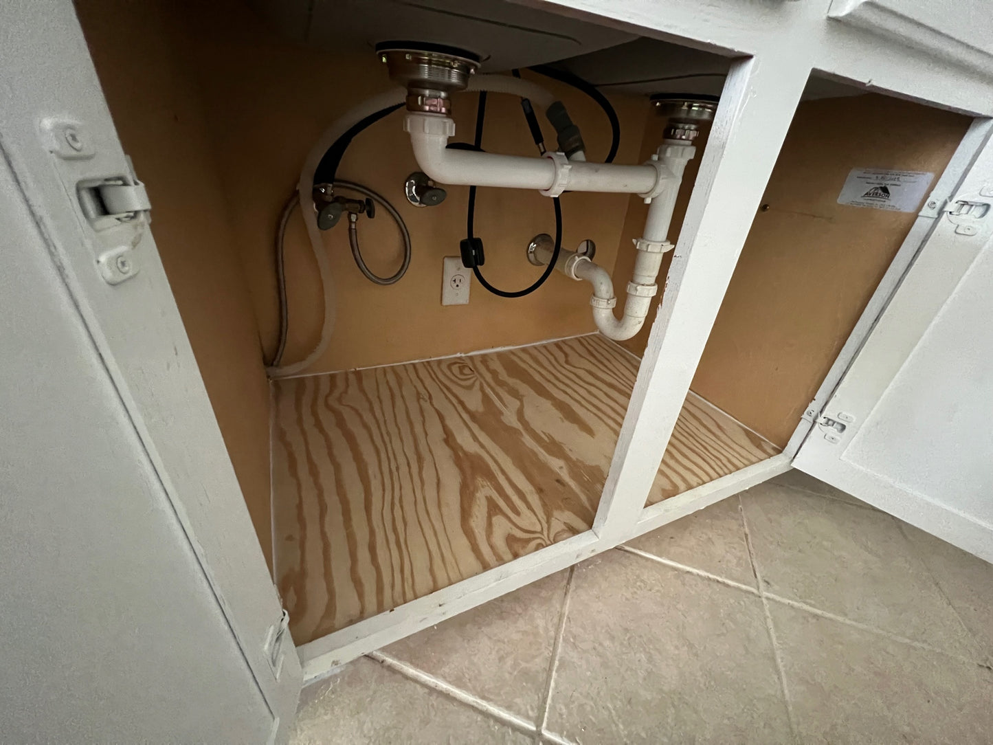 Kitchen sink cabinet with new wood bottom and drain leak repaired.